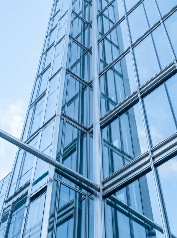 Glass facade of a modern building against a blue sky