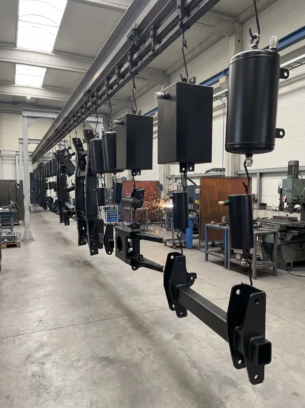 Black powder coated hydraulic tanks on a conveyor