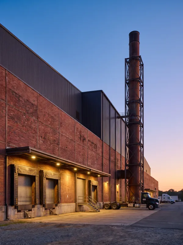 Brick and steel manufacturing plant with loading docks at dusk